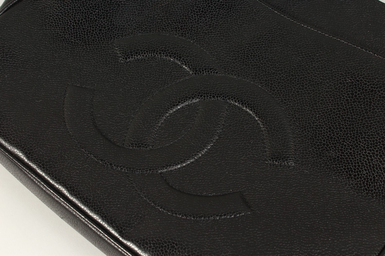 A BLACK LEATHER HANDBAG, with large embossed Chanel logo, leather handle, in a travelling bag. 32cms - Image 2 of 8