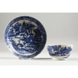 A WILLOW PATTERN DESIGN BLUE AND WHITE TEA BOWL AND SAUCER.