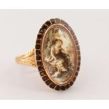 A GEORGIAN OVAL, GOLD AND RUBY SET RING, portrait of a young girl with a dog.