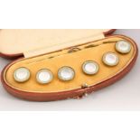 A SET OF SIX MOTHER-OF-PEARL STUDS, in a leather case.