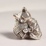 A SILVER KITTEN WITH BALL OF WOOL PIN CUSHION.