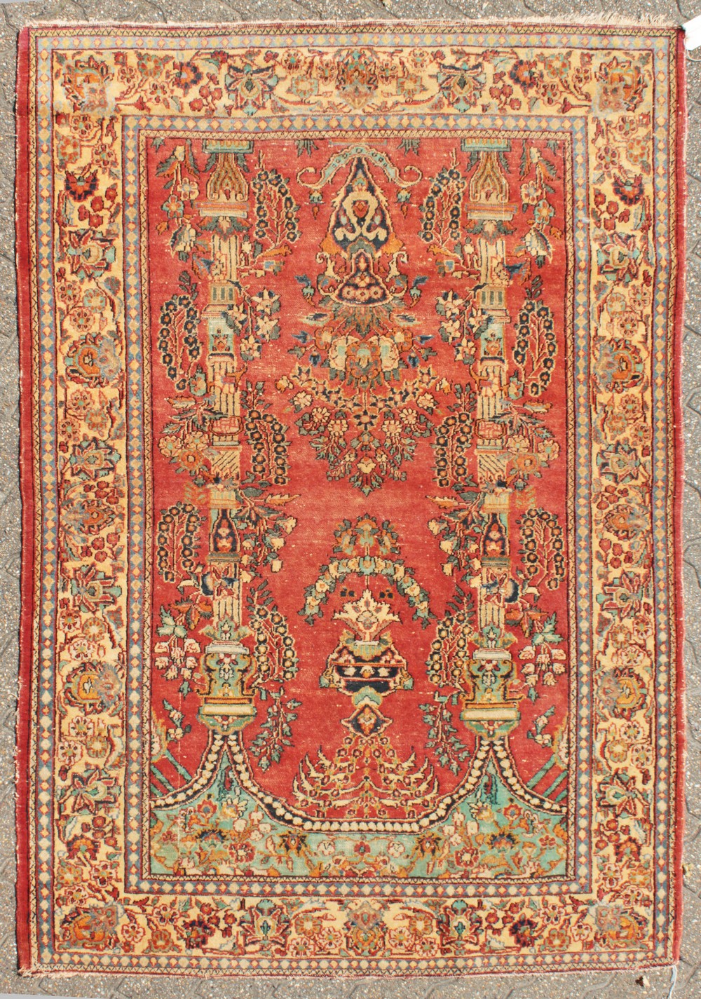 A PERSIAN KASHAN RUG with floral central motifs on a red ground with foliate border. 6ft 6ins x