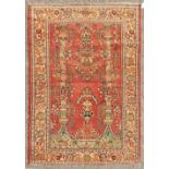 A PERSIAN KASHAN RUG with floral central motifs on a red ground with foliate border. 6ft 6ins x