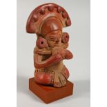 A PRE-COLUMBIAN STYLE POTTERY FIGURE ON STAND. 5.25ins high.