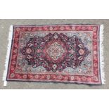 A GOOD PERSIAN SAROUK WOOL RUG with a large central motif on a blue ground with flower motifs on a