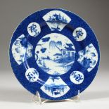 AN 18TH CENTURY BOW POWDER BLUE FAN PANELLED PLATE, painted with Chinese landscapes, the circular