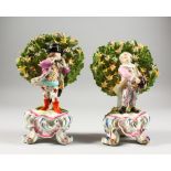 A PAIR OF CHELSEA RED ANCHOR BOCAGE FIGURES OF A BOY AND GIRL playing a hurdy-gurdy and a flute.