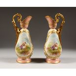 A PAIR OF SEVRES DESIGN EWERS, edged in gilt with panels of young lovers. 9.5ins high.