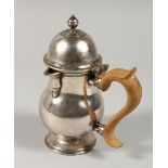 A QUEEN ANNE DESIGN WHITE METAL LIDDED JUG with wooden handle.