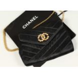 A SMALL BLACK QUILTED SATIN SHOULDER BAG, with diamante Chanel logo and gilt chain shoulder strap,