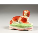 A STAFFORDSHIRE KING CHARLES SPANIEL INKWELL on a cushion base. 5ins long.