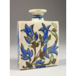 AN ISLAMIC SQUARE SHAPED FLASK, painted with flowers. 6ins high.