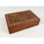 AN INDIAN CARVED WOOD BOX, carved with fruiting vines and flowers. 12ins wide.