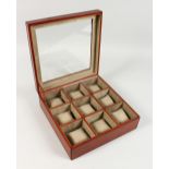 A LEATHER WATCH BOX, with nine compartments. 12ins wide.