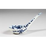 AN 18TH CENTURY WORCESTER RICE SPOON, painted in under-glaze blue with a busy floral pattern,