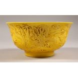 A YELLOW GROUND CHINESE BOWL, with moulded dragon decoration. 6ins diameter.