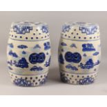 A PAIR OF POTTERY BARREL SEATS, with blue and white decoration. 18ins high.