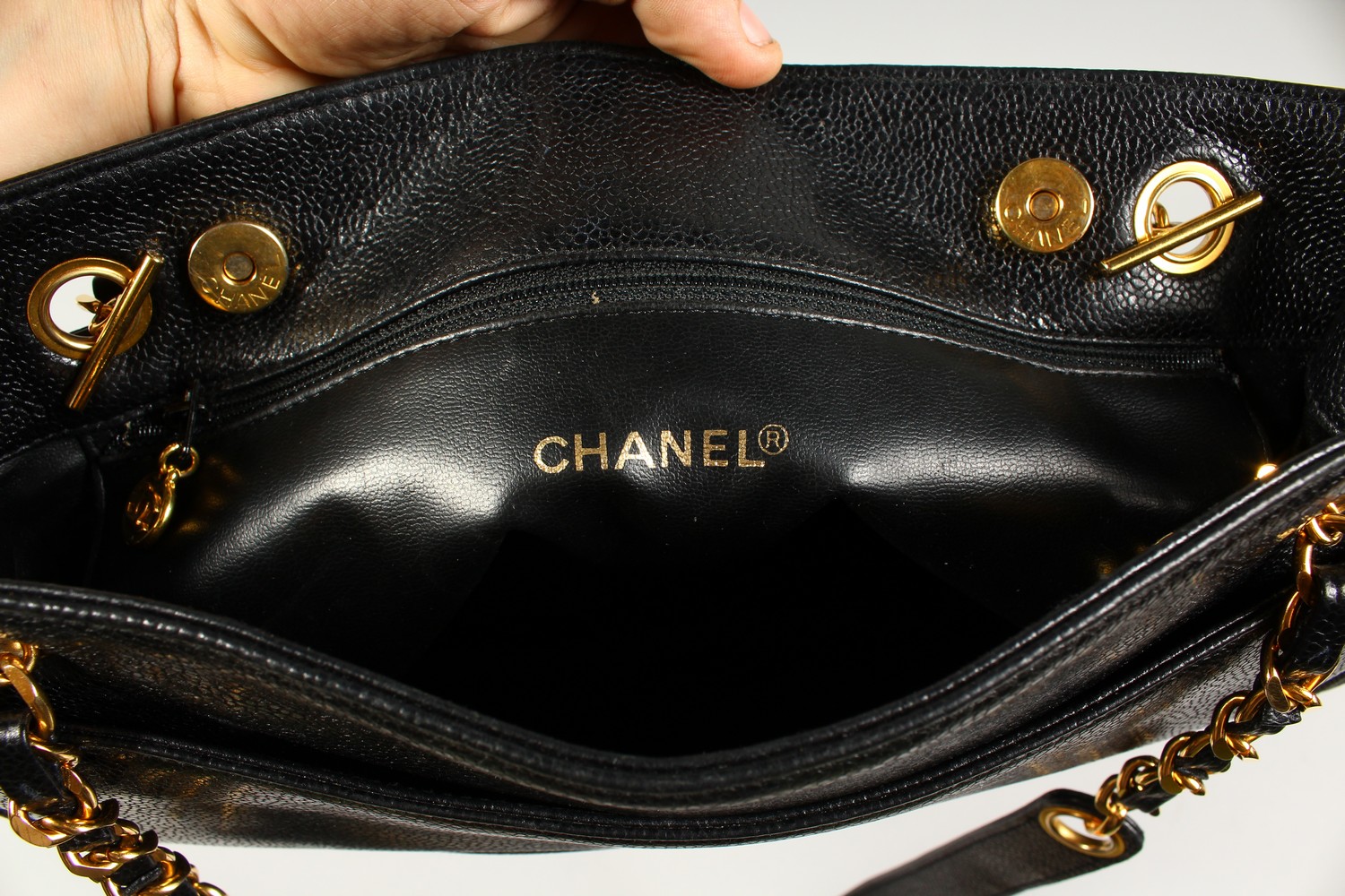 A BLACK LEATHER HANDBAG, with large embossed Chanel logo, leather handle, in a travelling bag. 32cms - Image 5 of 8