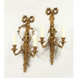 A PAIR OF FRENCH BRASS TWO-LIGHT WALL SCONCES, with cupids and ribbon motifs. 47cms long.