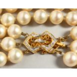 A THREE-ROW STRING OF PEARLS with diamond and gold clasp.