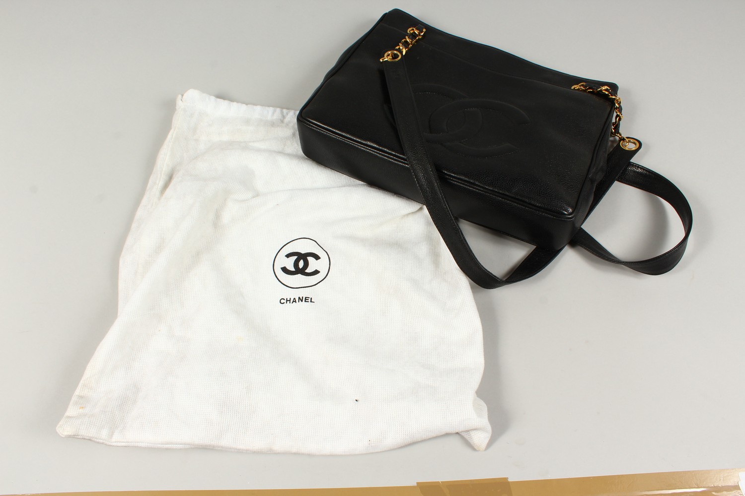 A BLACK LEATHER HANDBAG, with large embossed Chanel logo, leather handle, in a travelling bag. 32cms - Image 8 of 8