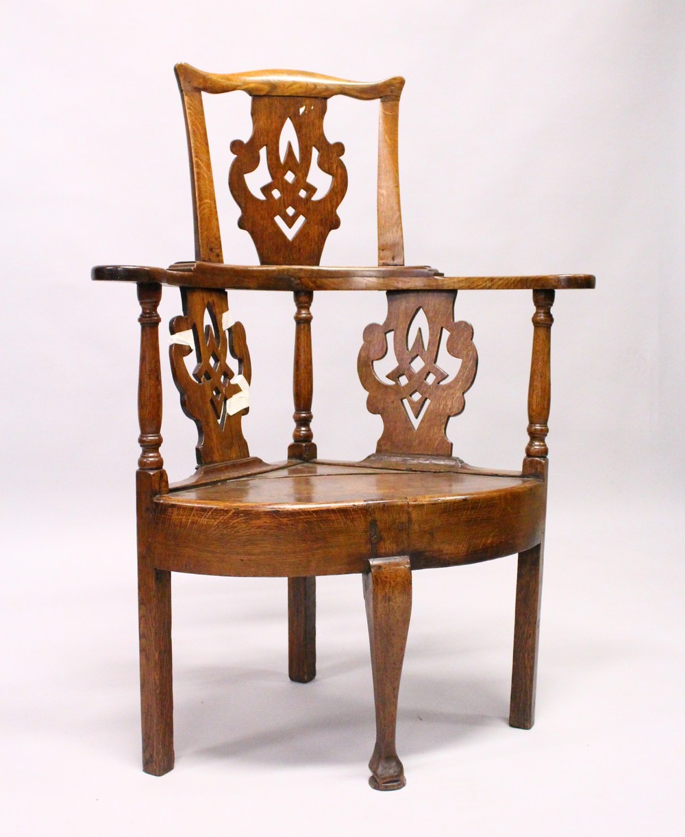 AN 18TH CENTURY OAK CORNER CHAIR, the curving back with pierced splats, solid seat on plain legs and