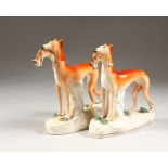 A PAIR OF STAFFORDSHIRE GREYHOUNDS with rabbits in their mouths. 7.5ins high.