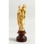 A GOOD 17TH-18TH CENTURY GOAN CARVED IVORY MADONNA AND CHILD on a circular wooden base. 6.25ins