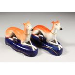 A PAIR OF STAFFORDSHIRE GREYHOUND INKWELLS on blue bases. 6ins long.