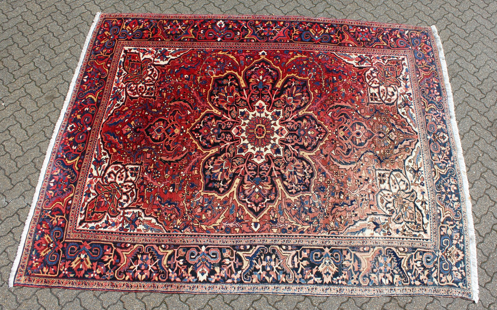 A PERSIAN STYLE HERIZ CARPET, 20TH CENTURY, red ground with allover stylised floral decoration (some