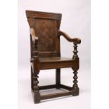 AN 18TH CENTURY OAK WAINSCOT ARMCHAIR, with carved back, solid seat and curving arms and turned