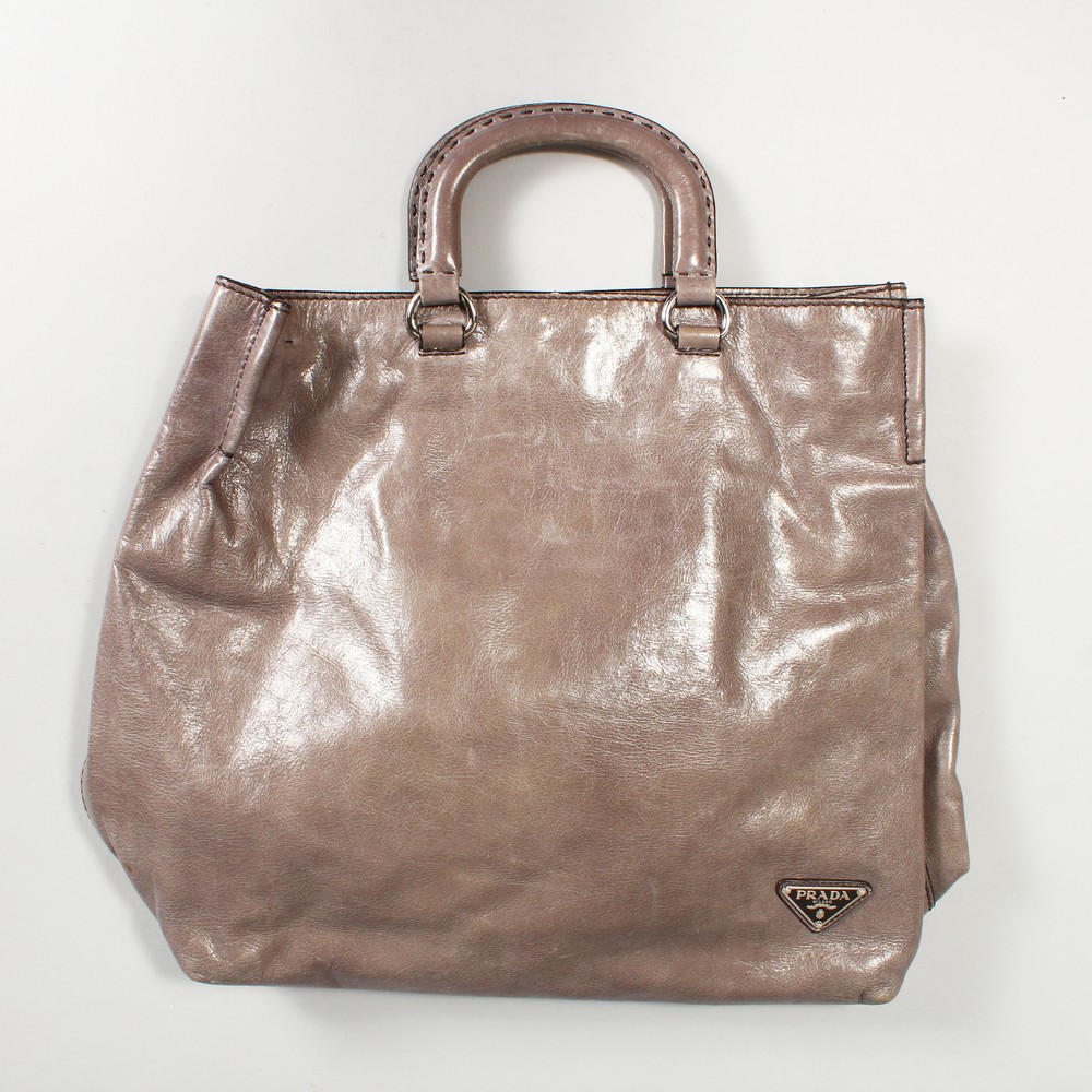 A LARGE MAUVE PRADA BAG, in a Prada bag.