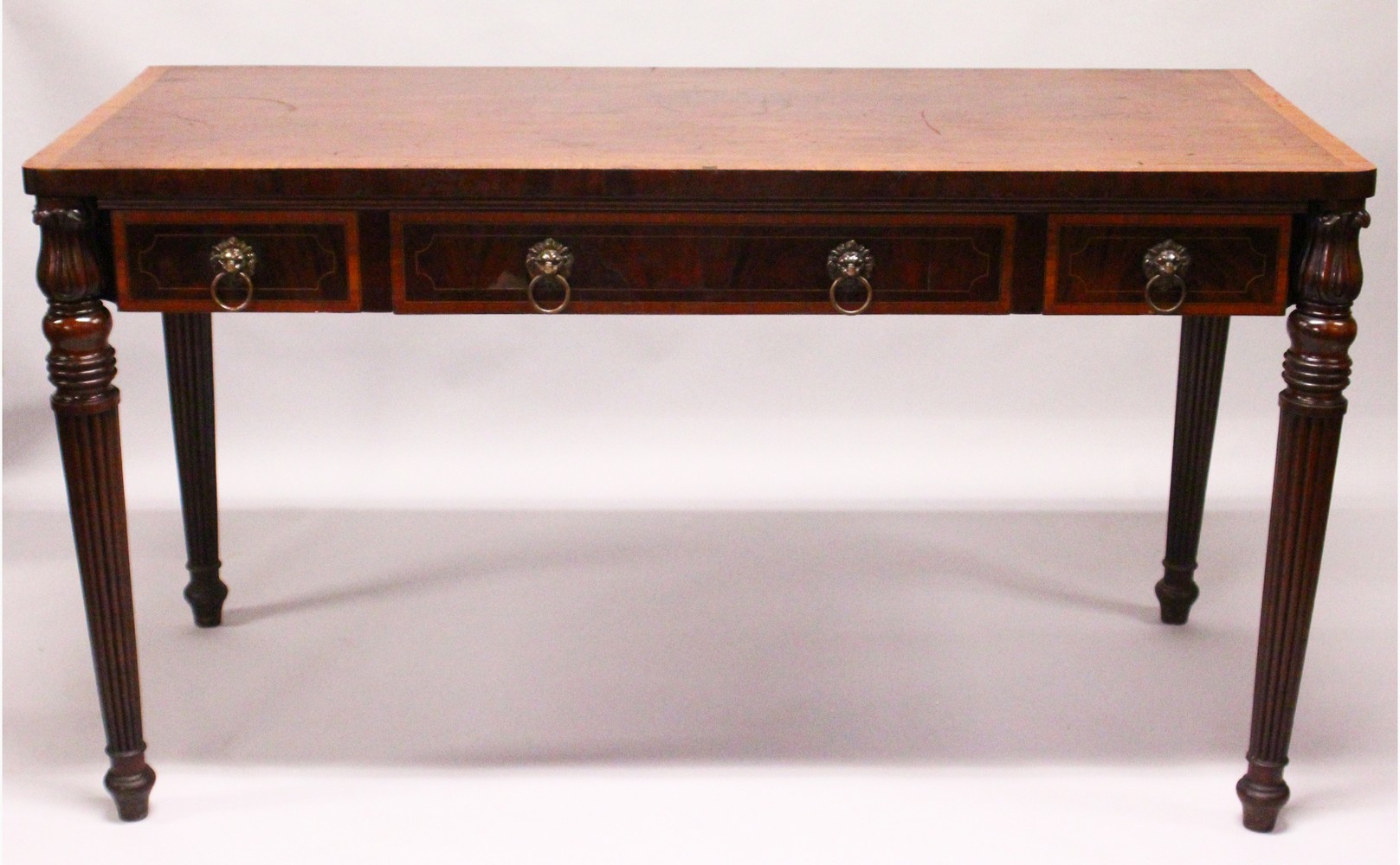 A 19TH CENTURY MAHOGANY AND SATINWOOD BANDED SERVING TABLE, with three frieze drawers having lion