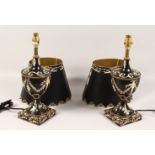 A PAIR OF BLACK TOLEWARE STYLE URN SHAPED TABLE LAMPS AND SHADES. 21ins high.