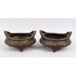 TWO GOOD CHINESE BRONZE TRIPOD CENSERS, Both with deep carved scenes of chilongs and archaic design,