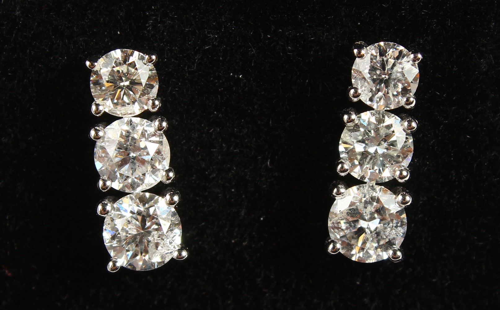 A GOOD PAIR OF 18CT WHITE GOLD THREE-STONE GRADUATED SET OF DIAMOND EARRINGS of 1.9CTS.