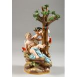 A GOOD MEISSEN GROUP OF TWO CHERUBS, seated beneath a tree working at a grindstone, crossed swords