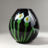 AN AMETHYST COLOUR STUDIO GLASS VASE, of bulbous shape, decorated with flowers, signed. 8.5ins