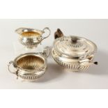 A THREE PIECE TEA SERVICE, comprising teapot, milk jug and sugar bowl, all with ribbed bodies.