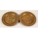 A PAIR OF BRASS CIRCULAR DISHES, engraved with birds amongst trees. 9.5ins diameter.