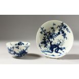 A WORCESTER BLUE AND WHITE TEA BOWL AND SAUCER, painted with a tree root and flowering prunus,