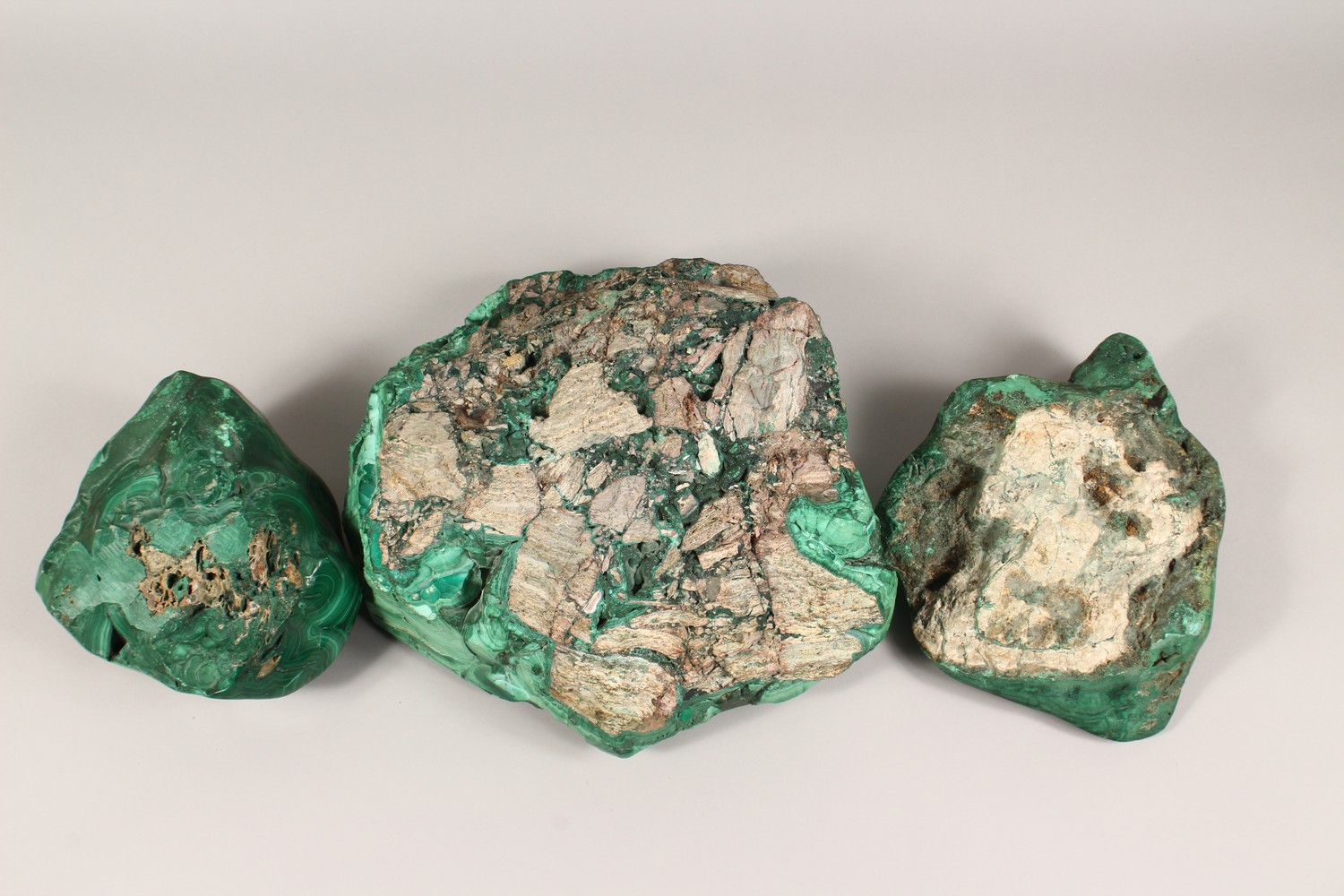 A LARGE NATURALISTIC PIECE OF MALACHITE, partially carved to form a dish, and two similar pieces ( - Image 6 of 9