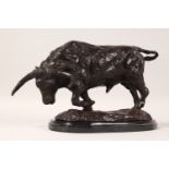 A NATURALISTIC BRONZE OF A STANDING BULL, on an oval marble base. 13ins long overall.