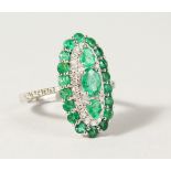A GOOD 18CT GOLD, EMERALD AND DIAMOND SET OVAL RING.