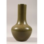 A GREEN GROUND BOTTLE VASE. 9ins high.