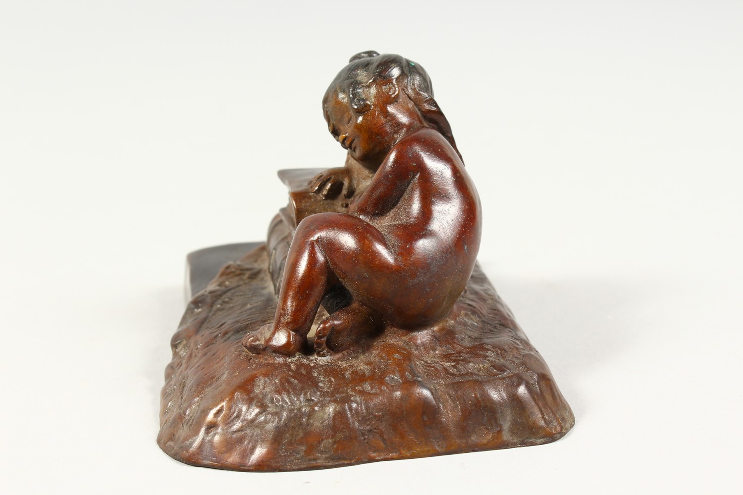 A SMALL CAST BRONZE MODEL OF A YOUNG GIRL ASLEEP AGAINST A PILE OF BOOKS. 5ins wide. - Image 2 of 6