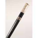 A BLACK LEATHER COVERED WALKING STICK, with eastern white metal mounts. 36ins long.