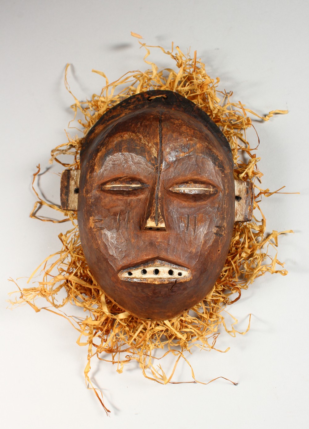 A CARVED WOOD TRIBAL MASK "TSHOKWE LWENA SHABA". 7.5ins high.