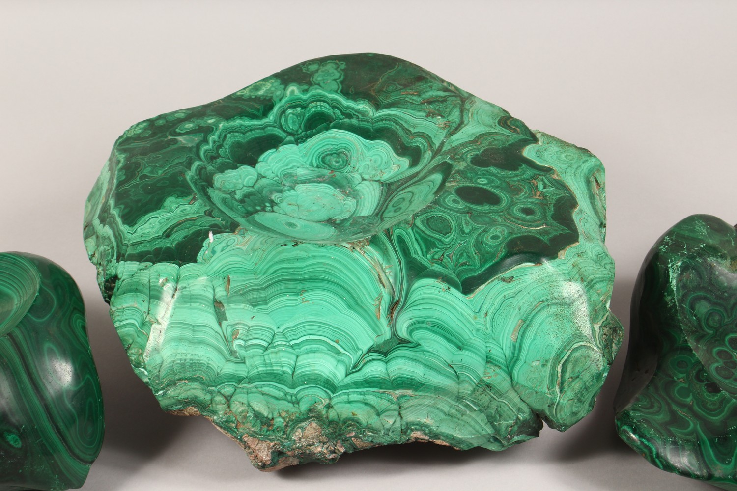 A LARGE NATURALISTIC PIECE OF MALACHITE, partially carved to form a dish, and two similar pieces ( - Image 3 of 9