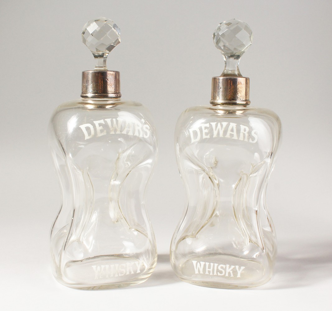 A PAIR OF DEWAR'S WHISKY HOURGLASS DECANTERS, with silver collars, marks rubbed. 10.5ins high.